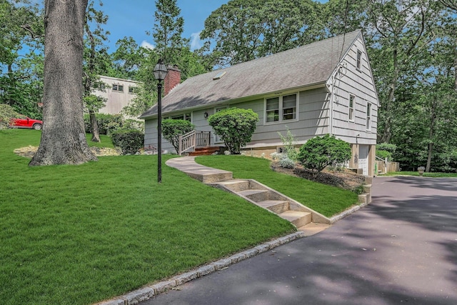 39 Dartmouth Rd, Shoreham, NY 11786 - view of front facade featuring a front yard, driveway, roof with shingles, a chimney, and a garage