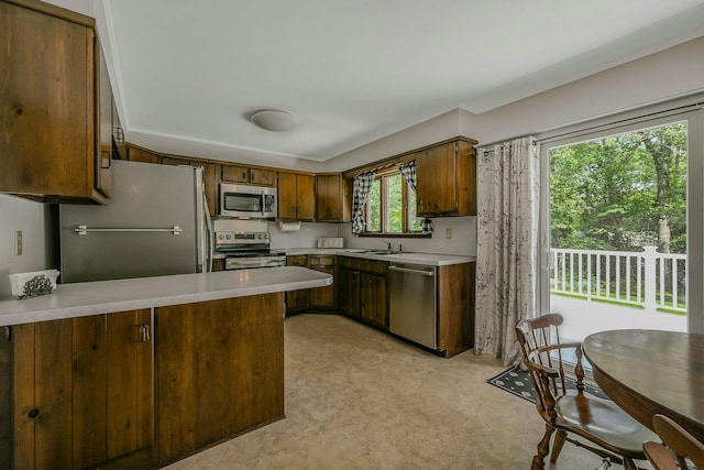 39 Dartmouth Rd, Shoreham, NY 11786 - kitchen with stainless steel appliances, light countertops, a peninsula, light colored carpet, and a sink