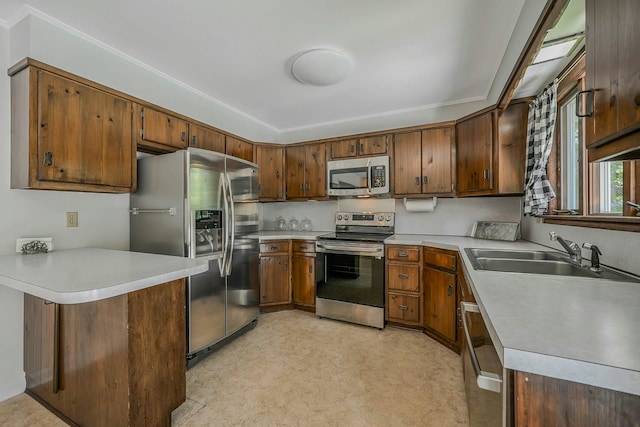 39 Dartmouth Rd, Shoreham, NY 11786 - kitchen featuring appliances with stainless steel finishes, a sink, light countertops, crown molding, and a peninsula