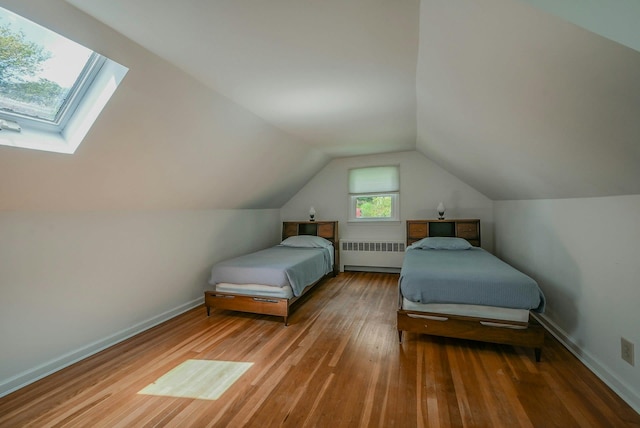39 Dartmouth Rd, Shoreham, NY 11786 - bedroom with radiator, wood finished floors, a skylight, lofted ceiling, and baseboards