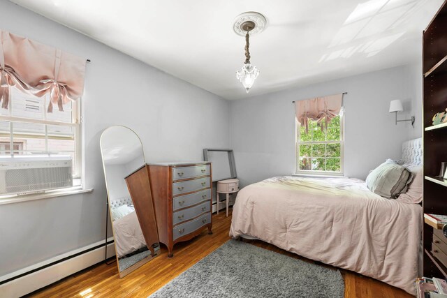 5922 Post Rd, Bronx, NY 10471 - bedroom featuring baseboard heating, wood finished floors, and cooling unit