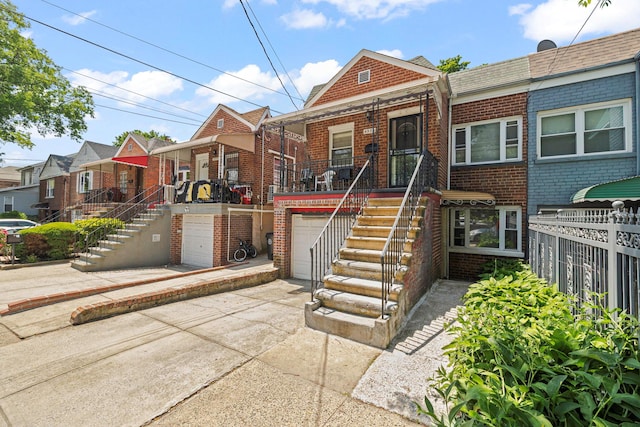 4331 Wilder Ave, Bronx, NY 10466 - view of front facade featuring brick siding, stairway, a garage, and concrete driveway