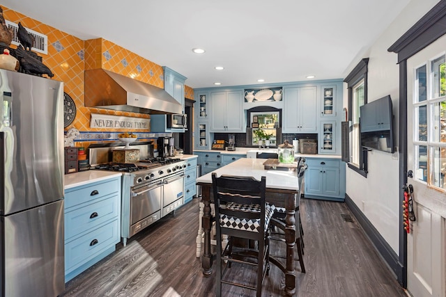 67 W Neck Rd, Huntington, NY 11743 - kitchen featuring appliances with stainless steel finishes, light countertops, wall chimney range hood, dark wood-style flooring, and tasteful backsplash