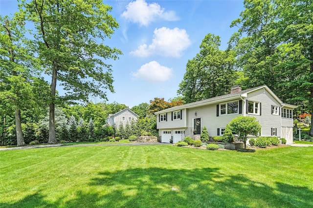 69 Clove Brook Dr, Cold Spring, NY 10516 - view of front of property with a garage, a chimney, a front lawn, driveway, and view of wooded area