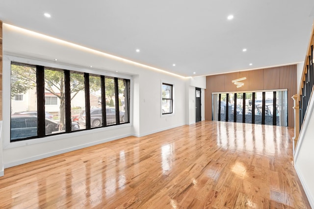 14428 Farmers Blvd, Rochdale, NY 11434 - unfurnished living room featuring recessed lighting, light wood-style floors, wood walls, and baseboards