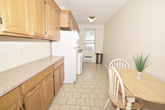 16 Main St Unit 3K, East Rockaway, NY 11518 - kitchen featuring white appliances, light countertops, light brown cabinetry, light tile patterned floors, and baseboards