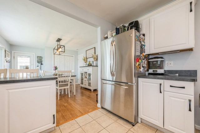 203 E Shore Rd, Lindenhurst, NY 11757 - kitchen with freestanding refrigerator, dark countertops, white cabinetry, light tile patterned floors, and pendant lighting