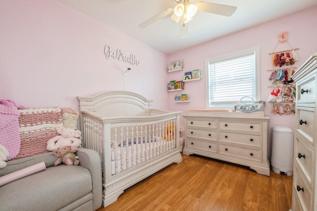 203 E Shore Rd, Lindenhurst, NY 11757 - bedroom featuring a nursery area, light wood-style flooring, and ceiling fan