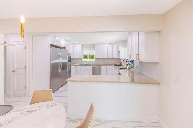 34 Winesap Ln, Monsey, NY 10952 - kitchen featuring appliances with stainless steel finishes, light marble finish flooring, a peninsula, white cabinetry, and a sink