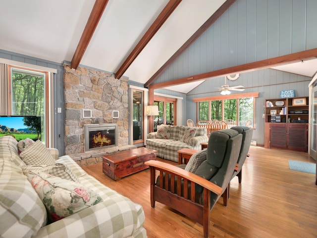 141 Mountain Laurel Ln, Glen Spey, NY 12737 - living room featuring light wood-style floors, a stone fireplace, ceiling fan, and wooden walls