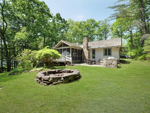 141 Mountain Laurel Ln, Glen Spey, NY 12737 - rear view of house featuring an outdoor fire pit, a sunroom, a chimney, a patio area, and a lawn
