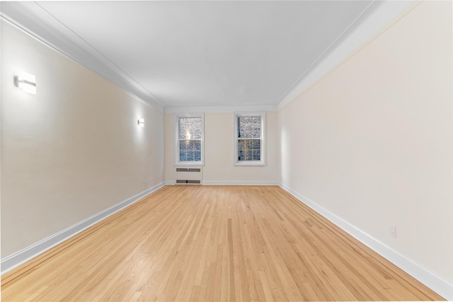 11007 73rd Rd Unit 4D, Forest Hills, NY 11375 - empty room with light wood-style flooring, ornamental molding, baseboards, and heating unit