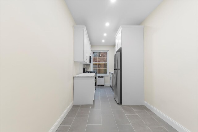 11007 73rd Rd Unit 4D, Forest Hills, NY 11375 - kitchen with appliances with stainless steel finishes, white cabinetry, recessed lighting, light countertops, and baseboards