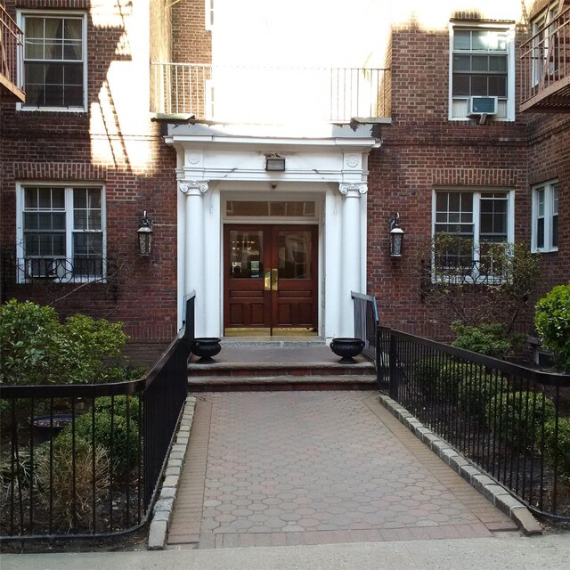11007 73rd Rd Unit 4D, Forest Hills, NY 11375 - property entrance featuring french doors, brick siding, and a balcony
