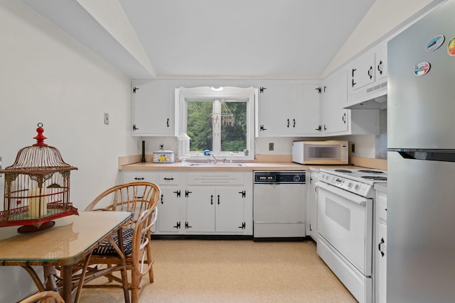24 Wellington Rd, Locust Valley, NY 11560 - kitchen with white appliances, lofted ceiling, under cabinet range hood, light countertops, and white cabinets