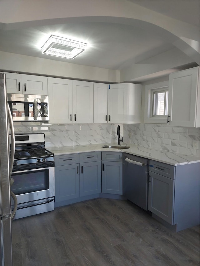 11 John Ave, Hempstead, NY 11003 - kitchen with stainless steel appliances, a sink, backsplash, white cabinets, and dark wood-style flooring
