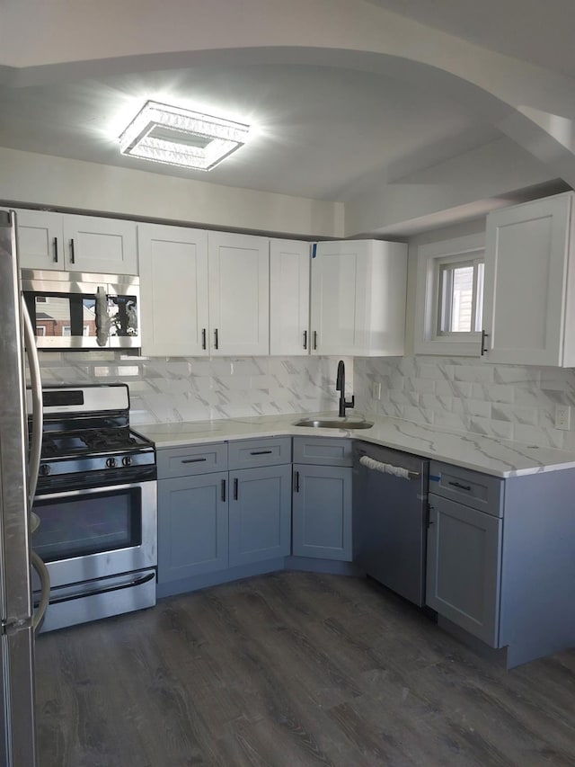 11 John Ave, Hempstead, NY 11003 - kitchen featuring appliances with stainless steel finishes, a sink, decorative backsplash, white cabinets, and dark wood-style flooring