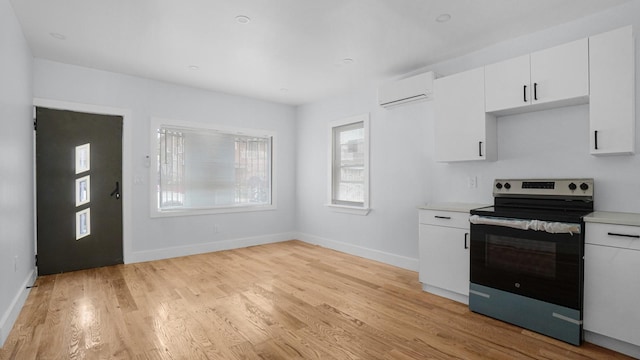 3919 Murdock Ave, Bronx, NY 10466 - kitchen with electric range, a wall mounted air conditioner, light countertops, light wood finished floors, and white cabinets