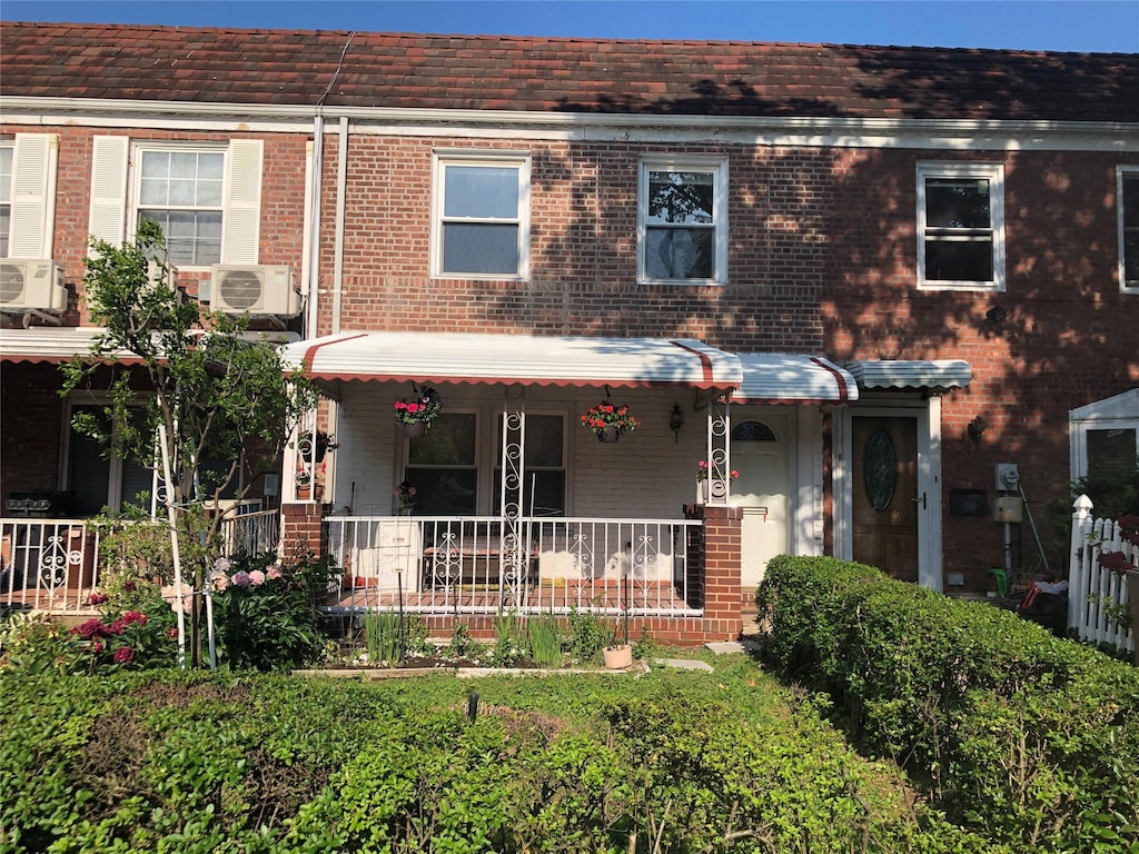 70-27 175th St, Fresh Meadows, NY 11365 - view of front facade with brick siding, covered porch, and ac unit