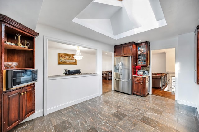 15 Fairway Dr, Old Bethpage, NY 11804 - kitchen featuring stainless steel fridge, glass insert cabinets, light countertops, a tray ceiling, and a chandelier