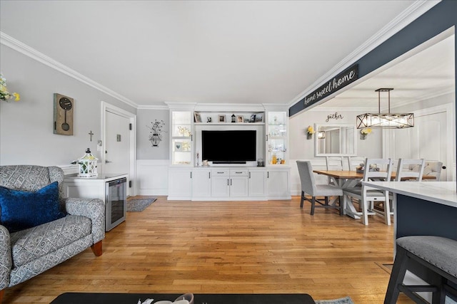 200 Merrick Rd Unit R, Amityville, NY 11701 - living area with crown molding, light wood finished floors, beverage cooler, a chandelier, and a wainscoted wall