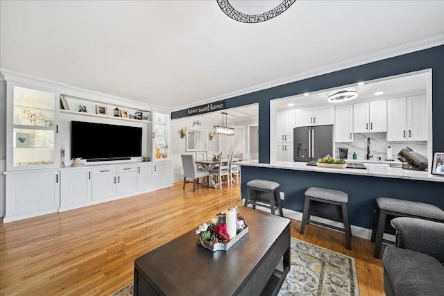 200 Merrick Rd Unit R, Amityville, NY 11701 - living area featuring crown molding, light wood finished floors, and built in shelves