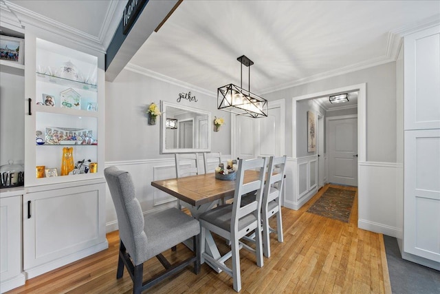 200 Merrick Rd Unit R, Amityville, NY 11701 - dining room with light wood-type flooring, crown molding, wainscoting, a decorative wall, and a chandelier