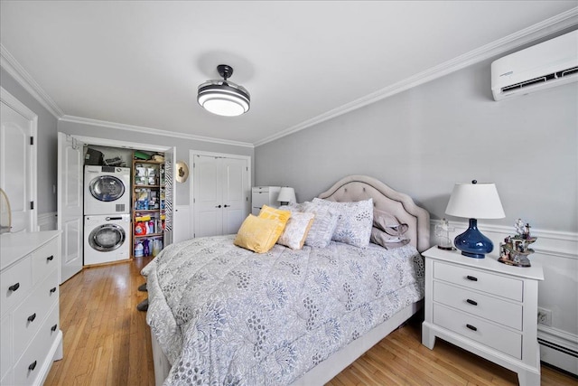 200 Merrick Rd Unit R, Amityville, NY 11701 - bedroom featuring stacked washer / drying machine, a baseboard heating unit, a wall unit AC, ornamental molding, and light wood-style flooring