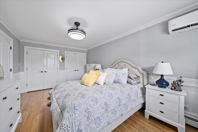 200 Merrick Rd Unit R, Amityville, NY 11701 - bedroom featuring two closets, an AC wall unit, a baseboard radiator, crown molding, and light wood-style flooring