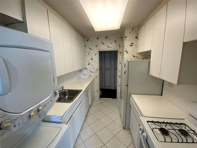 27110 Grand Central Pkwy Unit 11A, Floral Park, NY 11005 - kitchen featuring white gas stove, stacked washer / drying machine, a sink, light tile patterned floors, and light countertops