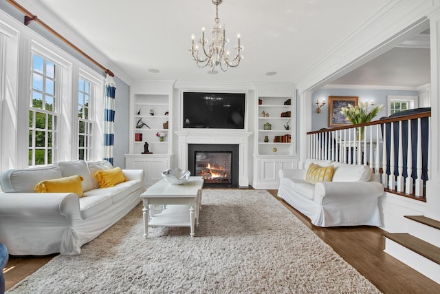 161 Wampum Ln, West Islip, NY 11795 - living area with a chandelier, a fireplace with flush hearth, ornamental molding, wood finished floors, and built in shelves