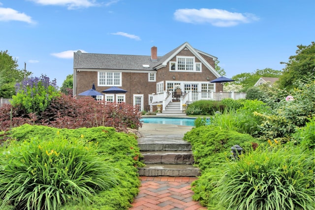 161 Wampum Ln, West Islip, NY 11795 - back of house with a wooden deck, an outdoor pool, and a chimney