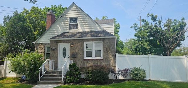 1779 Aladdin Ave, New Hyde Park, NY 11040 - view of front of property with stone siding, a chimney, and roof with shingles