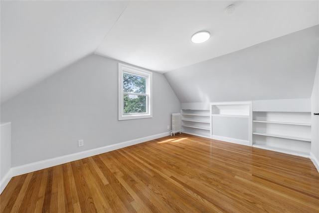 1779 Aladdin Ave, New Hyde Park, NY 11040 - bonus room featuring radiator, built in shelves, lofted ceiling, wood finished floors, and baseboards