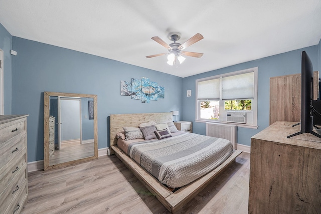 23 Edwards St Unit 1C, Roslyn Heights, NY 11577 - bedroom featuring radiator, baseboards, light wood-style flooring, and a ceiling fan