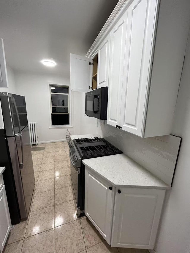 3591 161st St Unit 6L, Flushing, NY 11358 - kitchen featuring black microwave, freestanding refrigerator, range with gas stovetop, white cabinets, and radiator