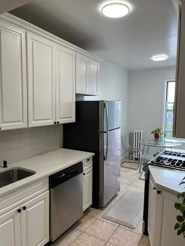 3591 161st St Unit 6L, Flushing, NY 11358 - kitchen with stainless steel dishwasher, radiator, white cabinets, light tile patterned flooring, and tasteful backsplash