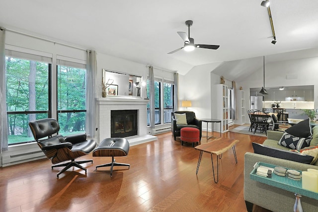 963 Heritage Hls Unit C, Somers, NY 10589 - living room featuring ceiling fan, lofted ceiling, wood finished floors, a brick fireplace, and baseboard heating