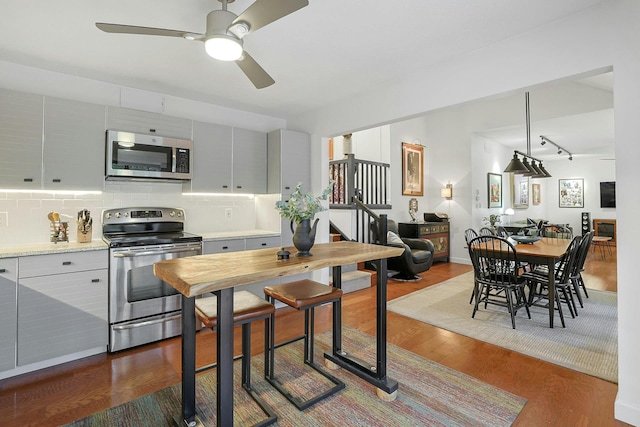 963 Heritage Hls Unit C, Somers, NY 10589 - kitchen with appliances with stainless steel finishes, dark wood-style floors, a ceiling fan, decorative backsplash, and gray cabinets