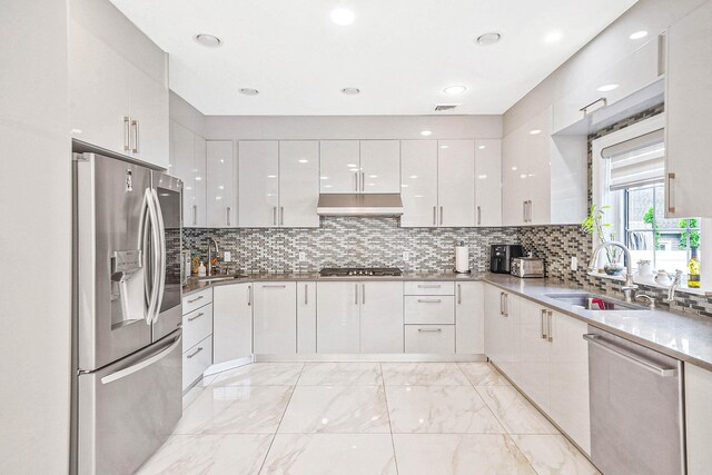 345 Washington Ave, Cedarhurst, NY 11516 - kitchen featuring stainless steel appliances, modern cabinets, under cabinet range hood, a sink, and light marble finish flooring