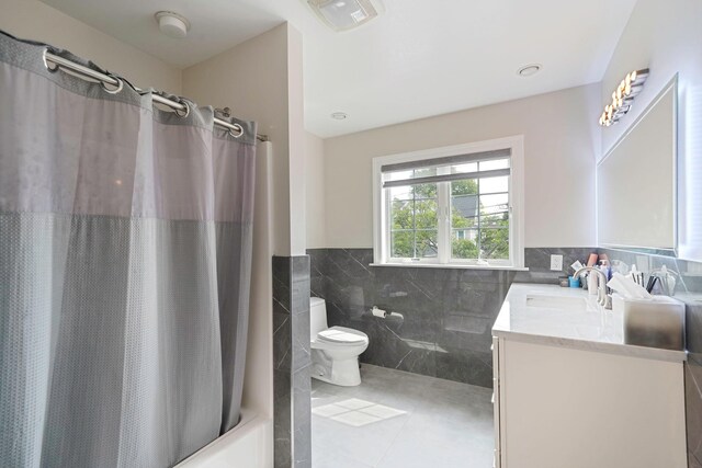 345 Washington Ave, Cedarhurst, NY 11516 - full bath with tile walls, toilet, vanity, tile patterned floors, and shower / tub combo