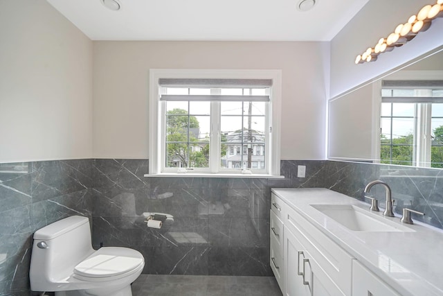345 Washington Ave, Cedarhurst, NY 11516 - bathroom featuring tile walls, toilet, vanity, tile patterned floors, and wainscoting