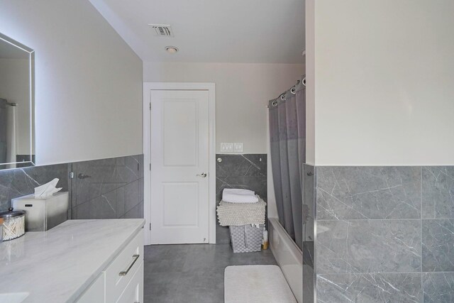345 Washington Ave, Cedarhurst, NY 11516 - full bathroom with tile walls, a wainscoted wall, vanity, and shower / bath combination with curtain