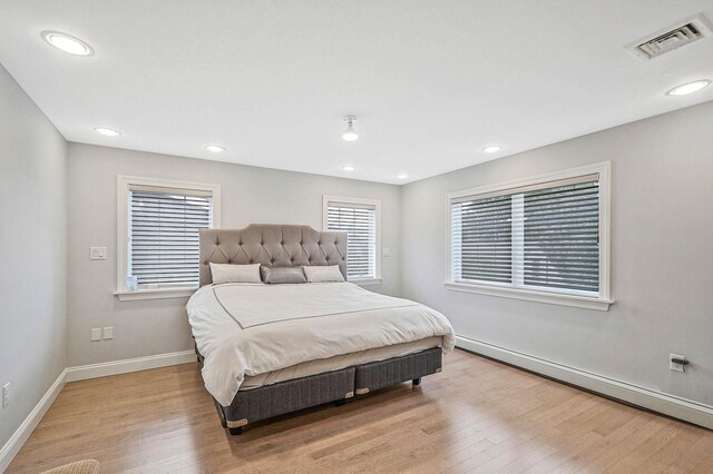 345 Washington Ave, Cedarhurst, NY 11516 - bedroom with wood finished floors, multiple windows, baseboards, a baseboard heating unit, and recessed lighting