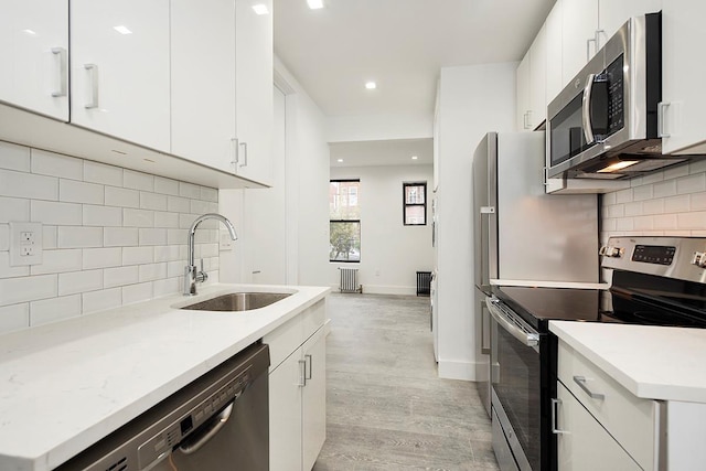 370 Rutland Rd, Brooklyn, NY 11225 - kitchen with stainless steel appliances, tasteful backsplash, light wood finished floors, white cabinets, and recessed lighting