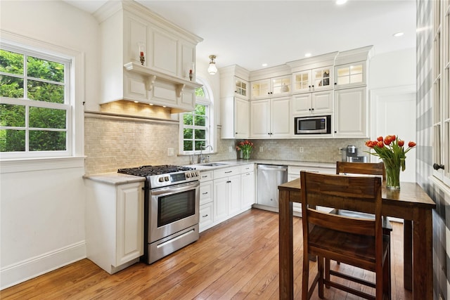58 Garden St, Garden City, NY 11530 - kitchen with appliances with stainless steel finishes, light wood-style flooring, white cabinets, tasteful backsplash, and recessed lighting