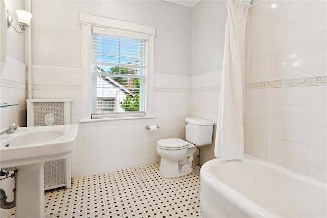 58 Garden St, Garden City, NY 11530 - bathroom featuring tile walls, a wainscoted wall, and shower / tub combo