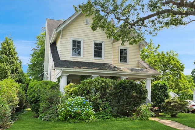 58 Garden St, Garden City, NY 11530 - view of side of property with a shingled roof, a lawn, and a porch