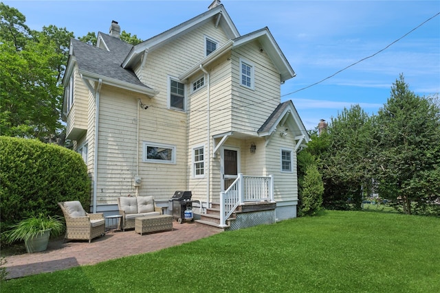 58 Garden St, Garden City, NY 11530 - rear view of house with a chimney, a lawn, a patio, outdoor lounge area, and roof with shingles