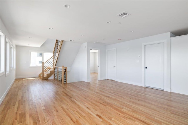 12 Pershing Pl, Island Park, NY 11558 - unfurnished living room featuring light wood finished floors, stairway, and recessed lighting